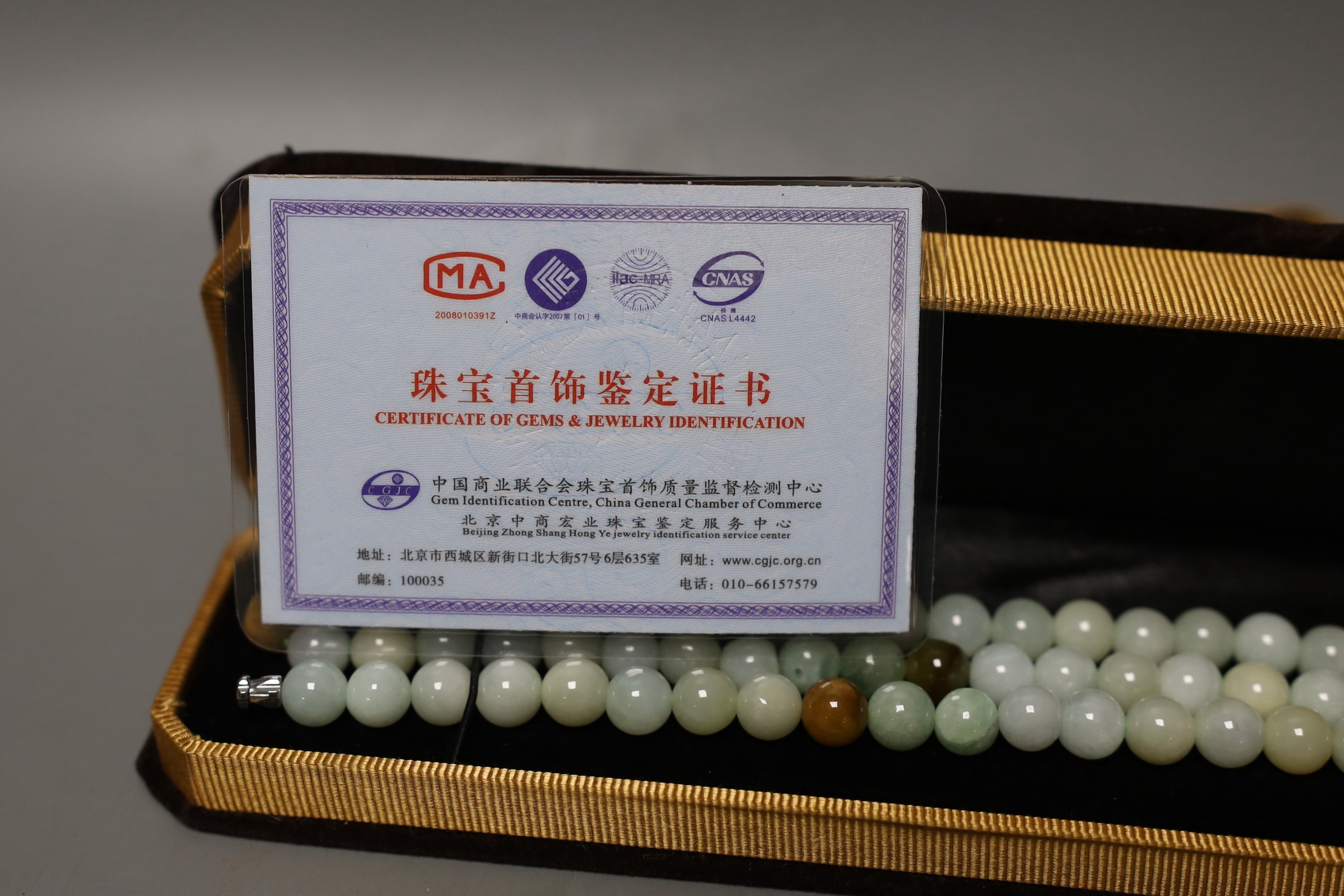 A boxed Chinese jade bead bracelet